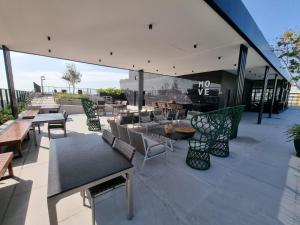 a patio with tables and chairs on a building at Flat Elegante c/ Varanda e Vista Mar - Tambaú in Tambaú
