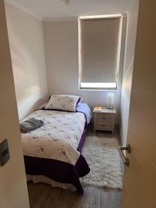 una piccola camera da letto con un letto e una finestra di Torre City House Temuco a Temuco