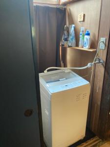 a washing machine in a room with a shelf at GuestHouse MIRAI in Tokamachi