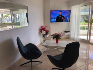 a living room with a table and two chairs and a tv at T2 & Garage FRONT DE MER résidence de Standing in Fréjus +31 photos