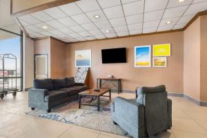 マディソンビルにあるDays Inn by Wyndham Madisonvilleのソファと薄型テレビのある待合室