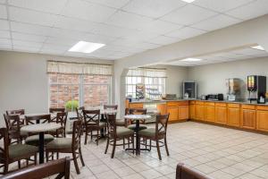 マディソンビルにあるDays Inn by Wyndham Madisonvilleのテーブルと椅子のあるダイニングルームとキッチン