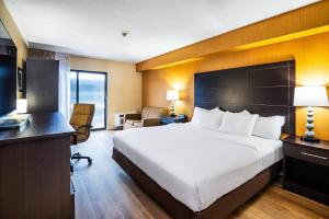 a hotel room with a large bed and a desk at Quality Inn in Barrie +29 photos