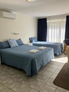 una camera da letto con due letti con asciugamani sopra di Emu Point Motel a Albany