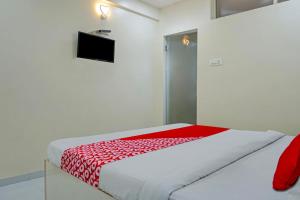 a bedroom with a bed with a red blanket on it at Super Hotel O Happy Homely Stay in Pune +22 photos