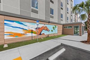 een muurschildering van een paard aan de zijkant van een gebouw bij Everhome Suites Ocala I-75 North in Ocala