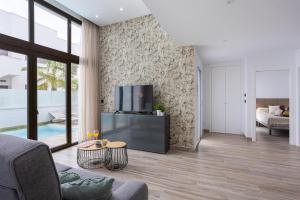 Laguna Beach Villa Veintidos في توريفايجا: غرفة معيشة مع تلفزيون وأريكة