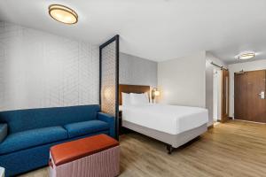 a hotel room with a bed and a blue couch at Everhome Suites Temecula Wine Country in Temecula +34 photos