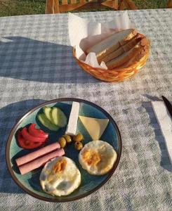 a plate of food with eggs and vegetables on a table at Guest House Artjoni Fierze in Fierzë