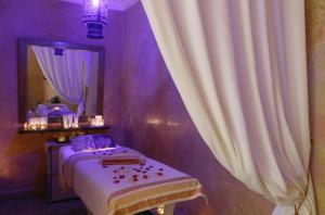 a bedroom with a bed and a mirror and curtains at Riad Dar Elma And Spa in Marrakesh