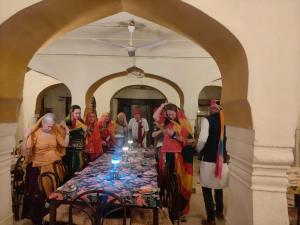 a group of people standing around a long table at Pachewar Garh - A Heritage Fort in Pachhewar +186 photos