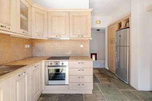 a kitchen with white cabinets and a refrigerator at Marilia VIllage Spathi Kea "Villa Helios" in Spathi  +18 photos