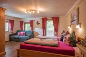 a bedroom with a large bed and a couch at Hof Neuhaus in Mayrhofen