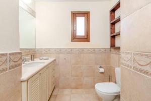 a white bathroom with a toilet and a sink at Marilia VIllage Spathi Kea "Villa Helios" in Spathi 