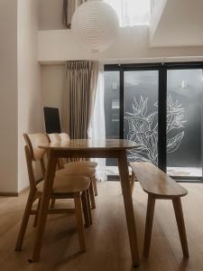 Un comedor con mesa y sillas de madera. en Heaven Thonglor 36 - Villa, en Bangkok