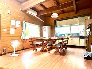 南小国町Whole house rental 天然温泉付きコテージRAI駐車場付き黒川温泉街まで車で5分的房间里有一张桌子和几把椅子的厨房