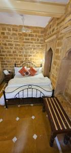 a bedroom with a bed and a wooden bench at The Travellers Cup Fort Stay in Jaisalmer +18 photos