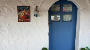 a blue door in a white wall with two windows at Maison de vacances pour 6 personnes in Tyros