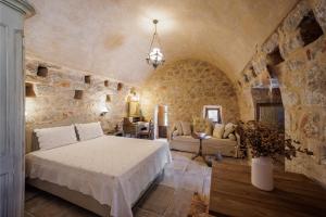 a bedroom with a bed and a stone wall at Arapakis Historic Castle in Pirgos Dhirou