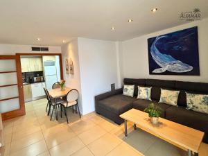 una sala de estar con un sofá y una mesa en Sakura Suite - Modern Apartment with Parking & Swimming Pool, en Lloret de Mar