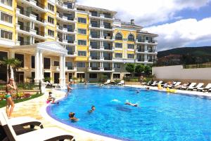 a group of people in a swimming pool next to a building at Romantic Studio Florence in Sveti Vlas