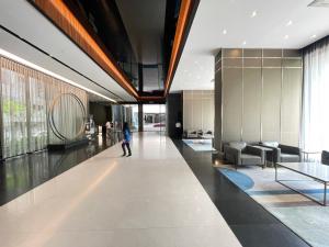 a person walking down a hallway in a building at Blue Haven Apartment at Opus Residence Kuala Lumpur in Kuala Lumpur +58 photos