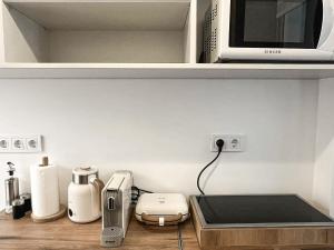 eine Küchentheke mit Mikrowelle und einigen Geräten in der Unterkunft Venetian Vicolo by CorfuEscapes in Korfu-Stadt + 5 Fotos