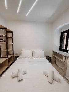 ein Schlafzimmer mit einem weißen Bett mit zwei Handtüchern darauf in der Unterkunft Venetian Vicolo by CorfuEscapes in Korfu-Stadt