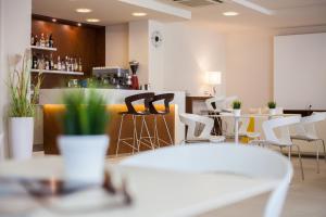 a restaurant with white chairs and a bar at Hotel Condor in Milano Marittima +38 photos