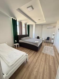 a bedroom with two beds and a wooden floor at Rooms ALEA in Sanski most