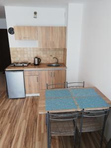 a kitchen with a table with chairs and a counter top at Pokoje Gościnne Ninikowo in Śliwin