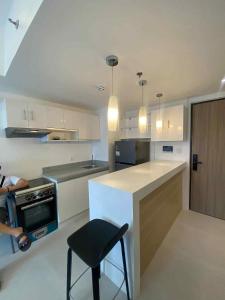 a kitchen with a counter and a chair in it at Cozy 1 bedroom at BE Residences Condominium with balcony near IT Park in Tabok
