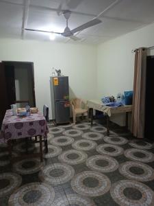 a room with two tables and a refrigerator at Quiet and Secure House, Hohoe in Hohoe