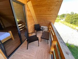 a room with two chairs and a bed on a porch at Cabana Alisa Sapanta in Săpânța +24 photos