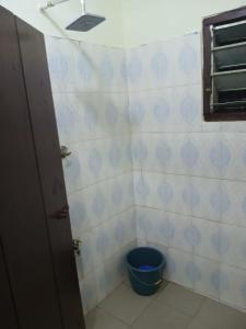 a small bathroom with a blue bucket in it at Quiet and Secure House, Hohoe in Hohoe
