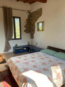 ein Schlafzimmer mit einem Bett und einer Steinwand in der Unterkunft Allulivus in Montenero