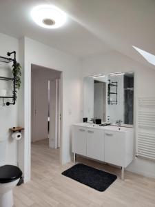 a white bathroom with a sink and a mirror at Maison 3 chambres in Trignac