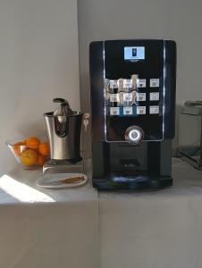 a coffee maker on a counter next to a bowl of oranges at alma de quireza in Santo Tomé