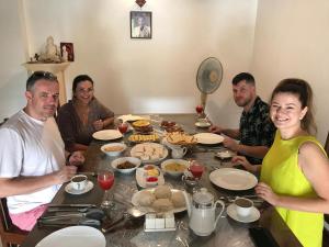 a group of people sitting around a table with food at Villa WG15 in Narandanda