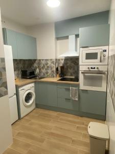 a kitchen with a washing machine and a microwave at PET FRIENDLY Casita Marín in Santa Pola +2 photos