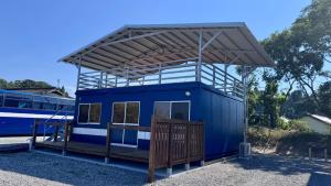 ein blaues Gebäude mit Markise neben einem Bus in der Unterkunft Porta Luce - Vacation STAY 83116v in Amakusa