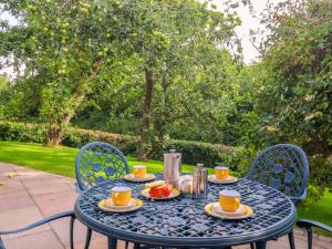 un tavolo blu con tazze e piatti di cibo sopra di Apple Tree Cottage a York