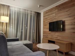 a living room with a couch and a tv on a wall at WESTIN HOUSE APARTAMENT 131 Kolobrzeg in Kołobrzeg