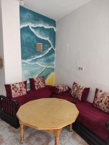 una sala de estar con un sofá y una mesa en earth home, en Imzoûrene