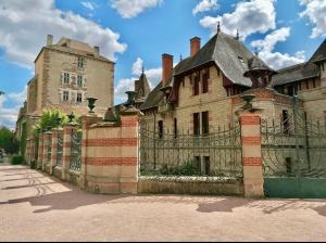 an old building with a gate and a castle at Le Jacquemart in Moulins