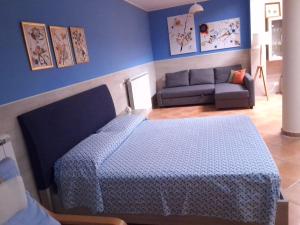 a blue bedroom with a bed and a couch at SantuMasi Bed & Breakfast in Gallipoli