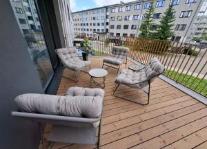 a wooden deck with chairs and a table on a balcony at New delux appartement in Keila