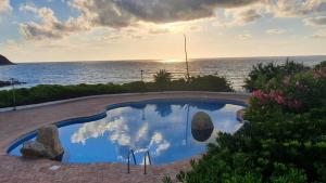 a swimming pool with a view of the ocean at Sunset House in Parghelia