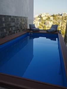 una piscina azul con vistas a la ciudad en Panoramic Voula's View Apartment, en Atenas