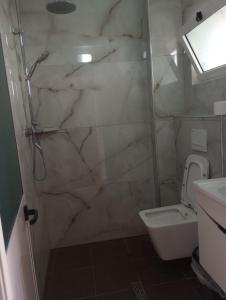 a bathroom with a shower and a toilet at Rooms and Apartments Analipsi in Shëngjin +27 photos